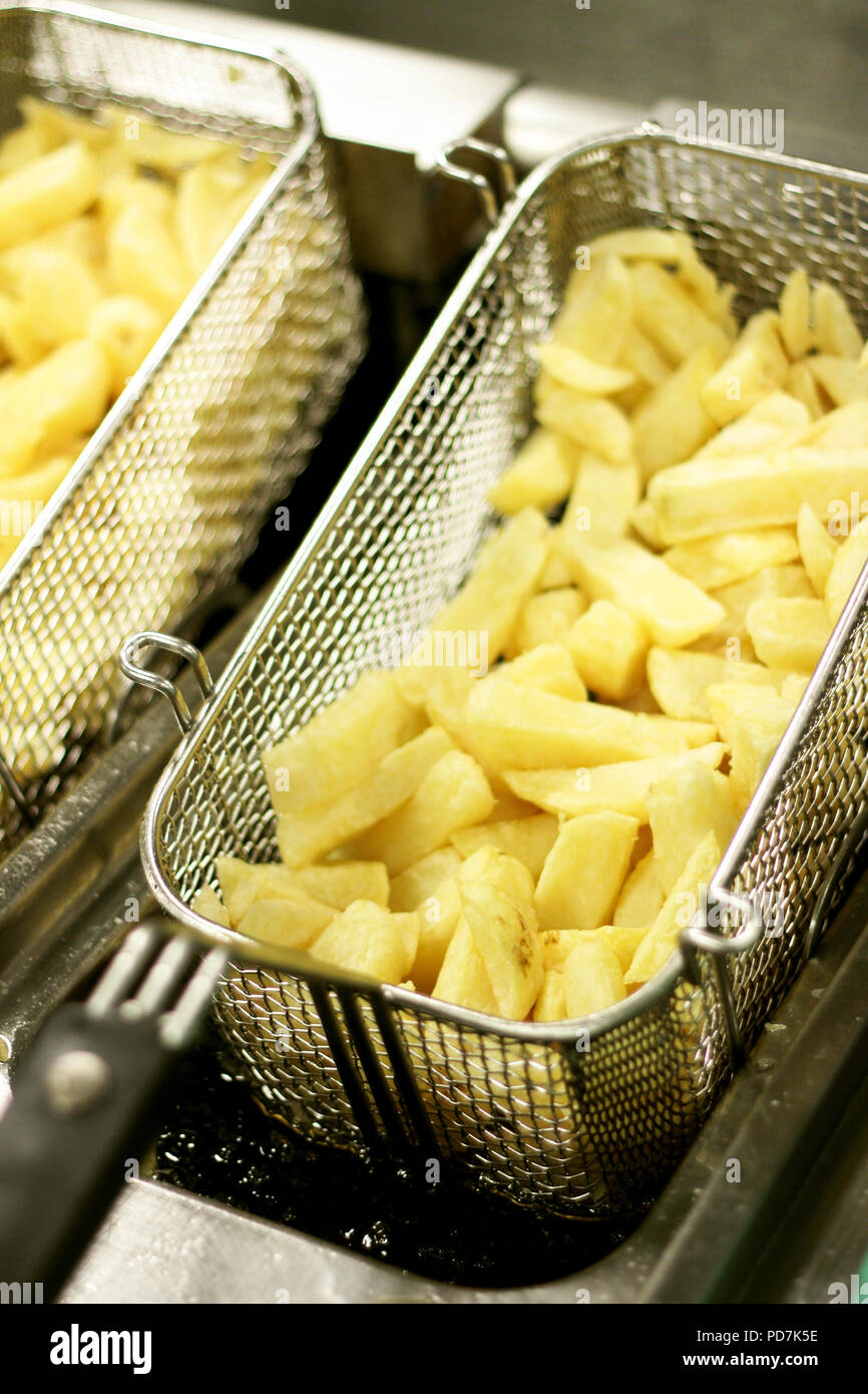 La frittura scaglie di patate nella friggitrice Foto Stock