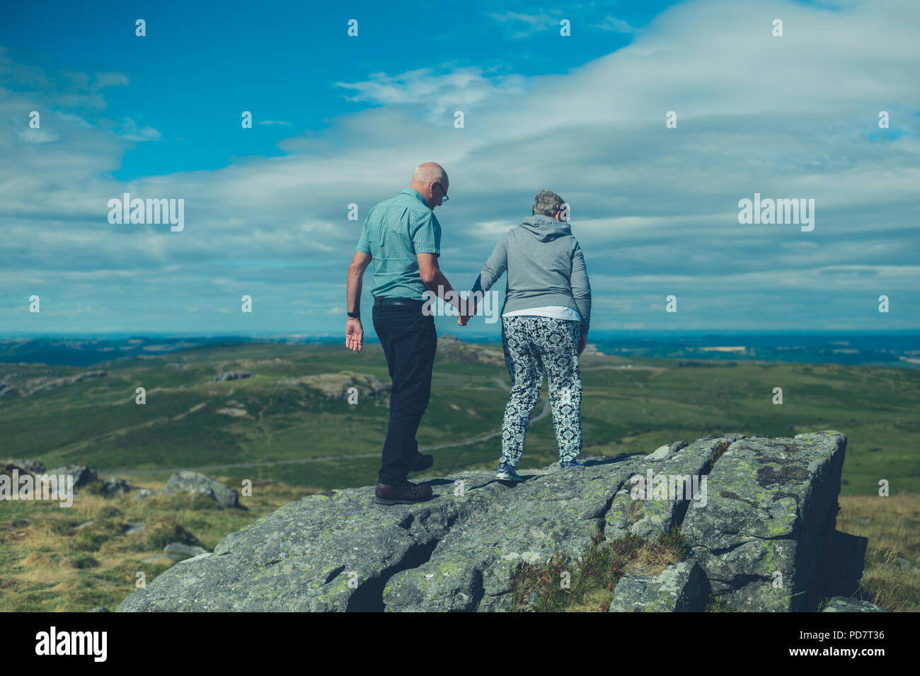 Una coppia senior sono in piedi su una roccia nel moro in estate Foto Stock