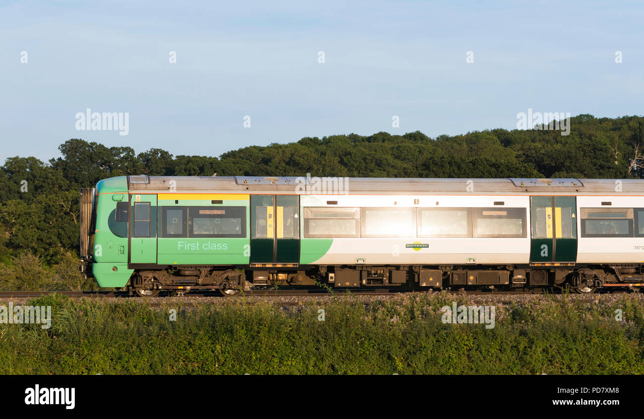 La British Rail Southern Classe 377 Electrostar treno in viaggio attraverso la campagna di sera con bassa sun riflettendo nel West Sussex, in Inghilterra, Regno Unito. Foto Stock