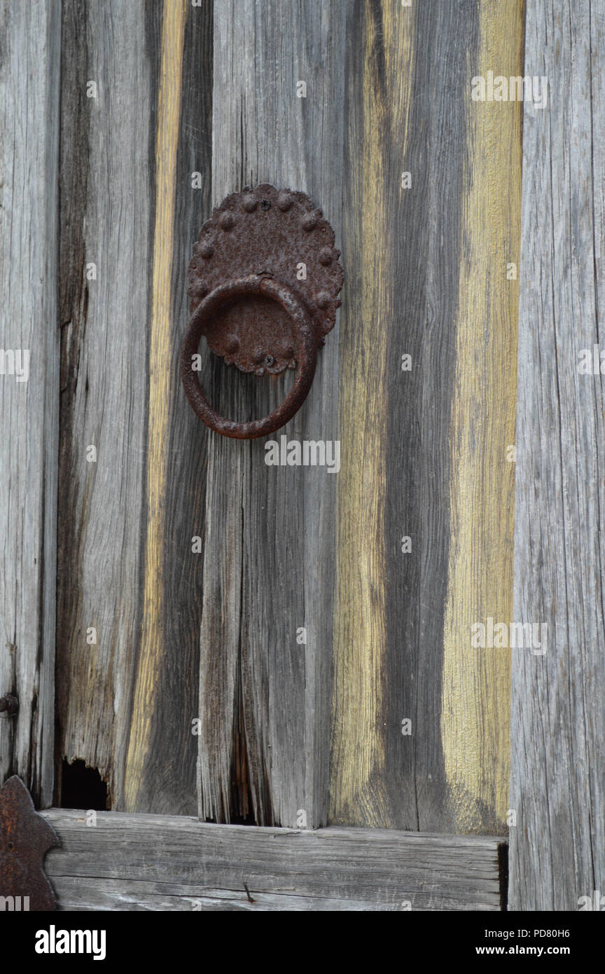 Close-up di chiodi arrugginiti respingente sul Weathered porta in legno Foto Stock