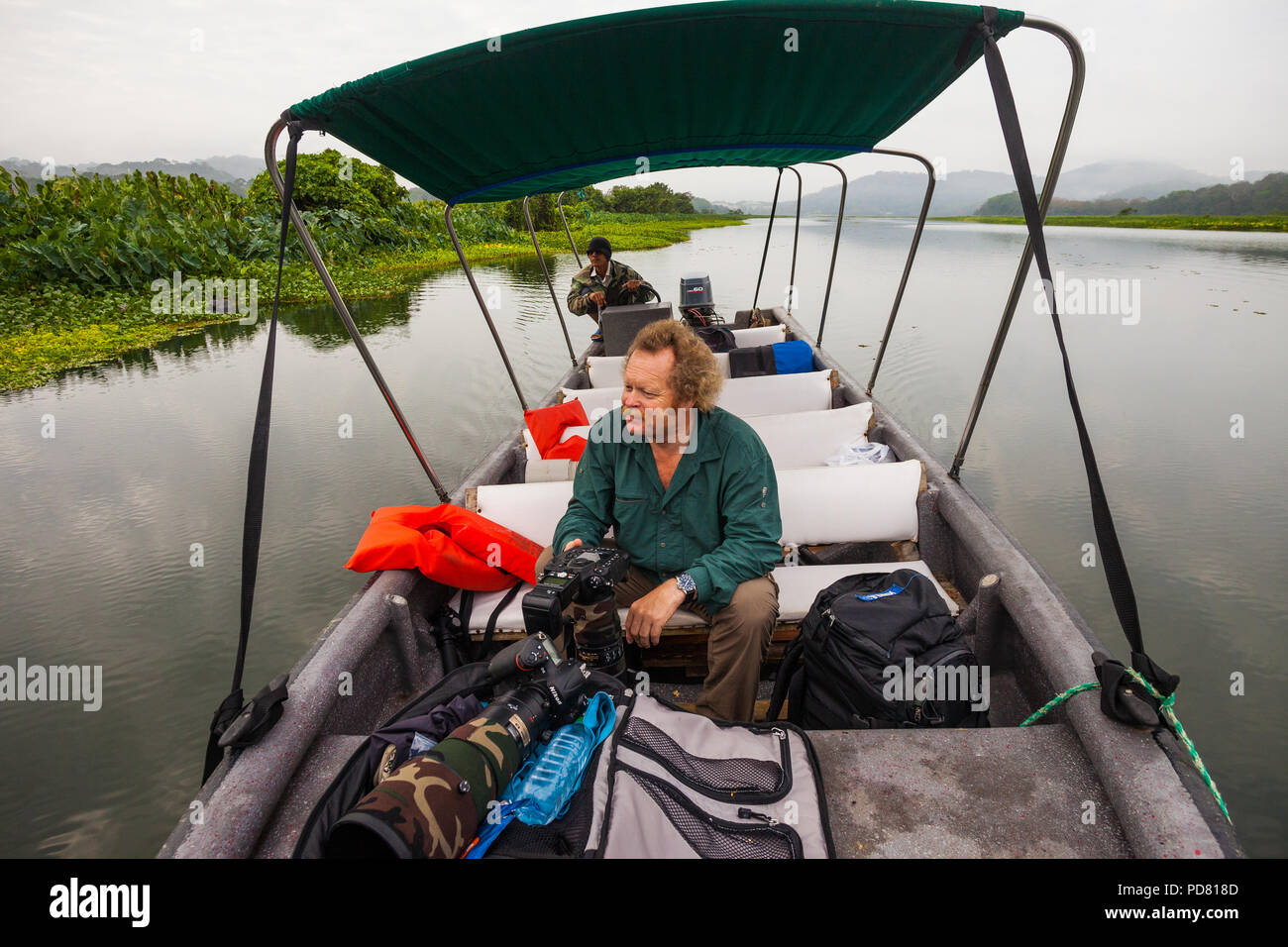 Wildlife Photographer con teleobiettivi in una barca sul Rio Chagres, parco nazionale di Soberania, Repubblica di Panama. Foto Stock