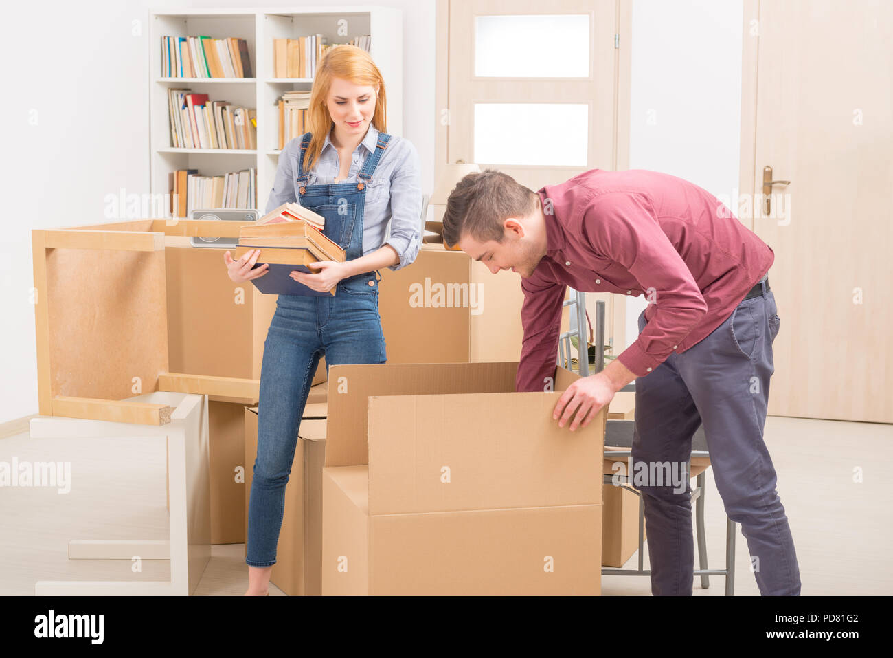 Felice coppia giovane disimballaggio caselle nella loro nuova casa Foto Stock