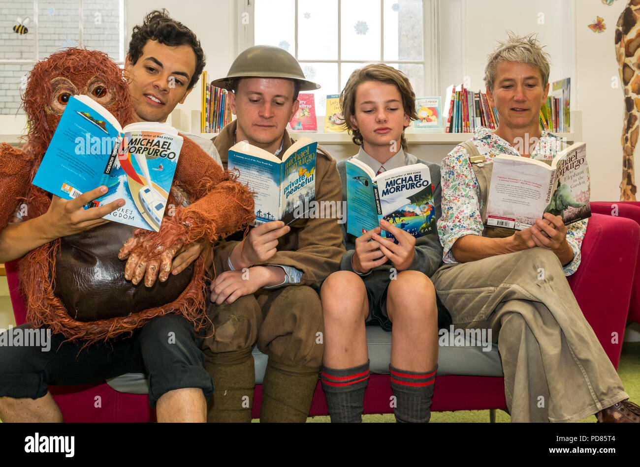 Edinburgh Fringe Festival di Edimburgo, Regno Unito. Il 7 agosto 2018. Biblioteca centrale, Edimburgo, Scozia Regno Unito: Photocall per cast di fringe mostra sulla base di libri per bambini da Michael Morpurgo. Il picaro Teatro pacifico privato con Andy Daniel, Poonamallee la produzione un elefante in giardino con Lizzie giocato da Alison Reid; Aquila la guerra di Jenkin l orecchio con Toby Jenkins ha giocato da Atticus Christie-Miller e produzione WildChild Kensuke è unito con Michael giocato da Aaron Douglas; Biblioteca dei bambini con gli attori la lettura di libri Foto Stock