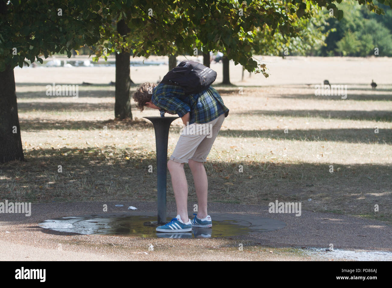 Londra REGNO UNITO. Il 7 agosto 2018. Un uomo che beve da una fontana di acqua nei giardini di Kensington su che cosa è l'ultimo giorno caldo prima di temperature finalmente cominciare a goccia e il fresco è prevista con i temporali prevista per porre fine alla Gran Bretagna è 35C canicola Credito: amer ghazzal/Alamy Live News Foto Stock