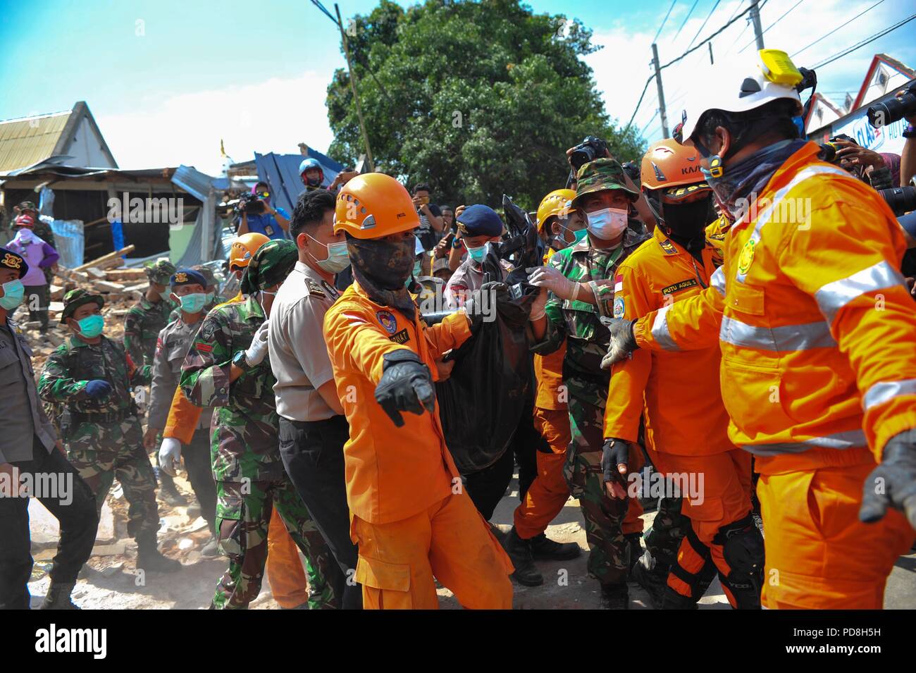 Lombok, Indonesia. 8 Ago, 2018. Soccorritori trasferire un corpo della vittima dalle macerie causate dal terremoto nel nord di Lombok, West Nusa Tenggara provincia, Indonesia, e il Agosto 8, 2018. Credito: Zulkarnain/Xinhua/Alamy Live News Foto Stock