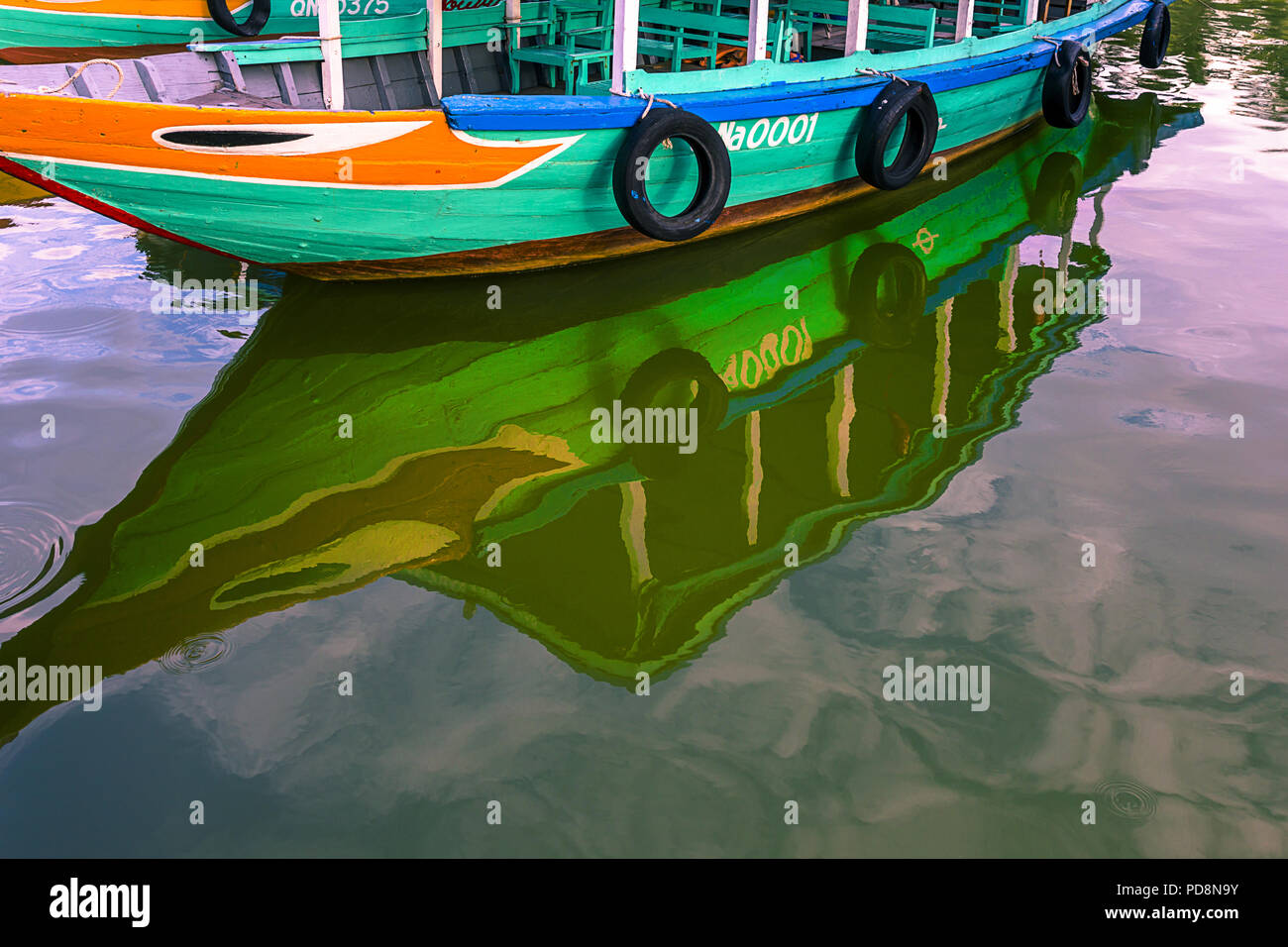 Riflessioni da quella del porto di colorate barche in Hoi An centro turistico acque. La città antica, VN Foto Stock