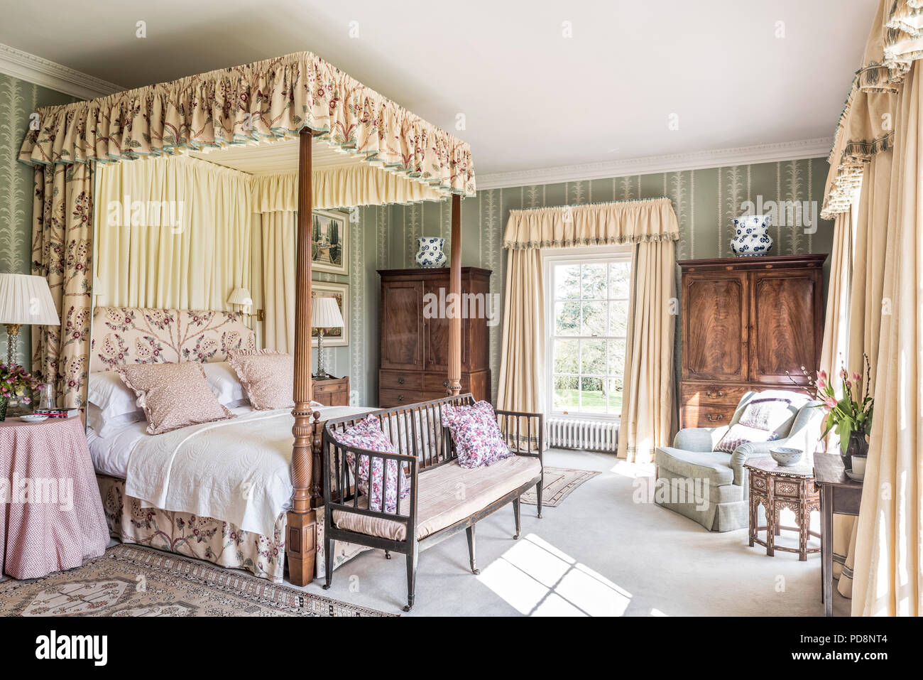 Coppia di armadi in legno e tessuti color crema su quattro-postered bed Foto Stock
