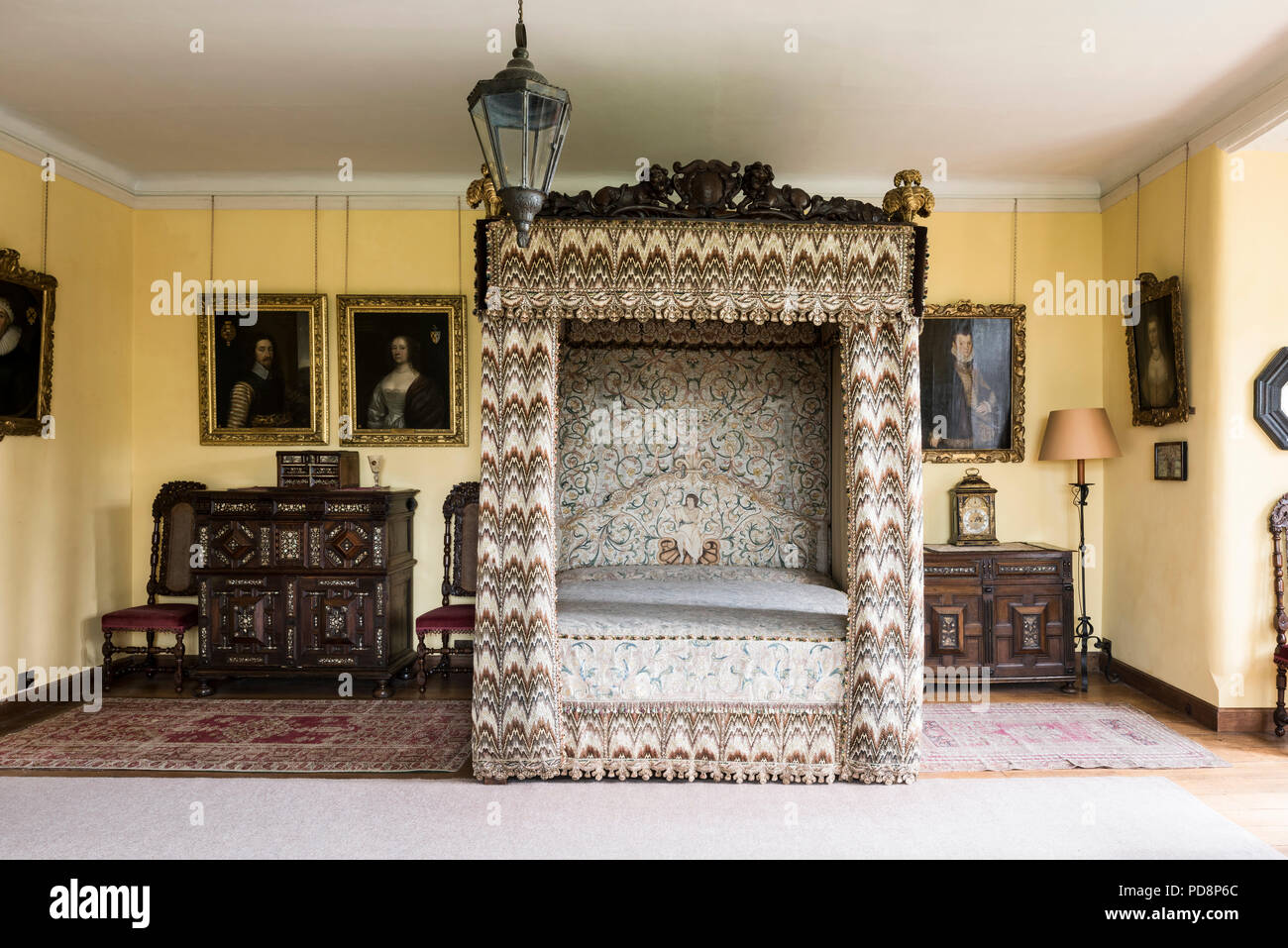 Quattro postered letto con il XVII secolo cucitura a fiamma ricami dorati e opere incorniciate sopra mobili intarsiati Foto Stock