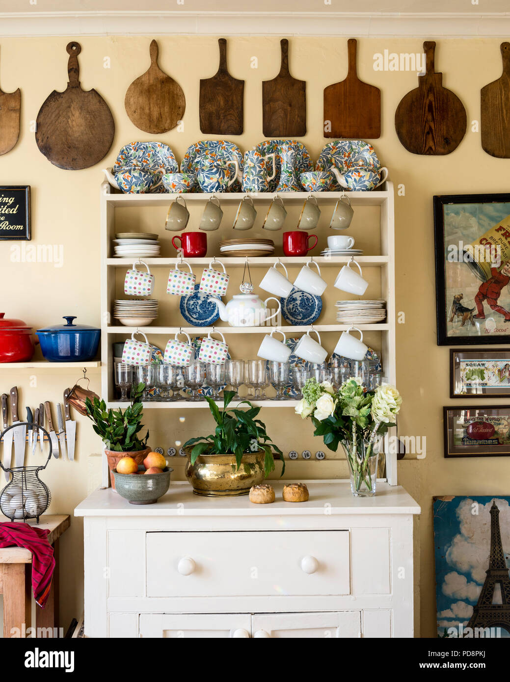 Blu, bianco e arancione "fantasia" la Cina da Barker Bros sul top della cucina dresser adornata con tazze e bicchieri. Una raccolta di schede di pelatura fa un str Foto Stock