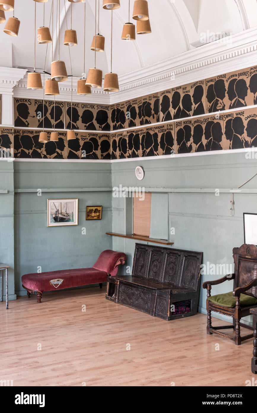 Le sagome di schizzo in passato i membri del Club che adornano le pareti della sala club con un travagliato chaise longue e un Tudorial banco hall Foto Stock