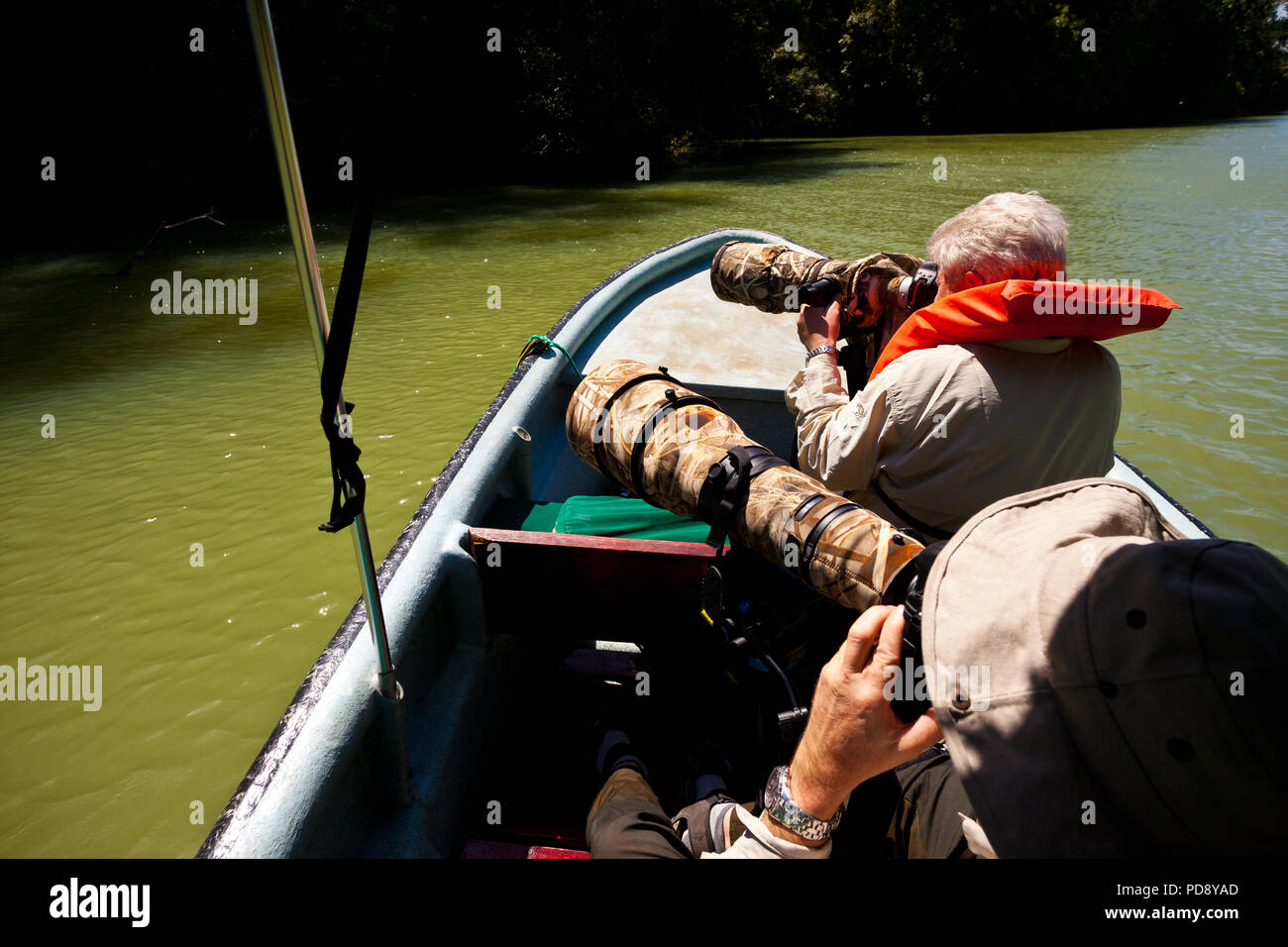 Due fotografi di fauna selvatica con grandi teleobiettivi in una barca in una delle armi bianche di Gatun Lago, Repubblica di Panama. Foto Stock