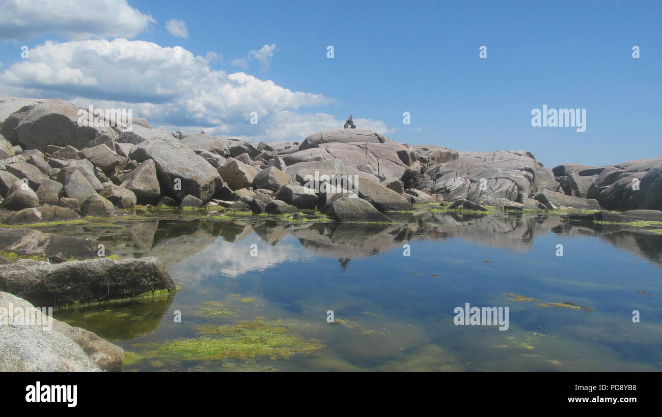 Peggy's Cove faro in Canada circondata da rocce inukshuks e turisti Foto Stock