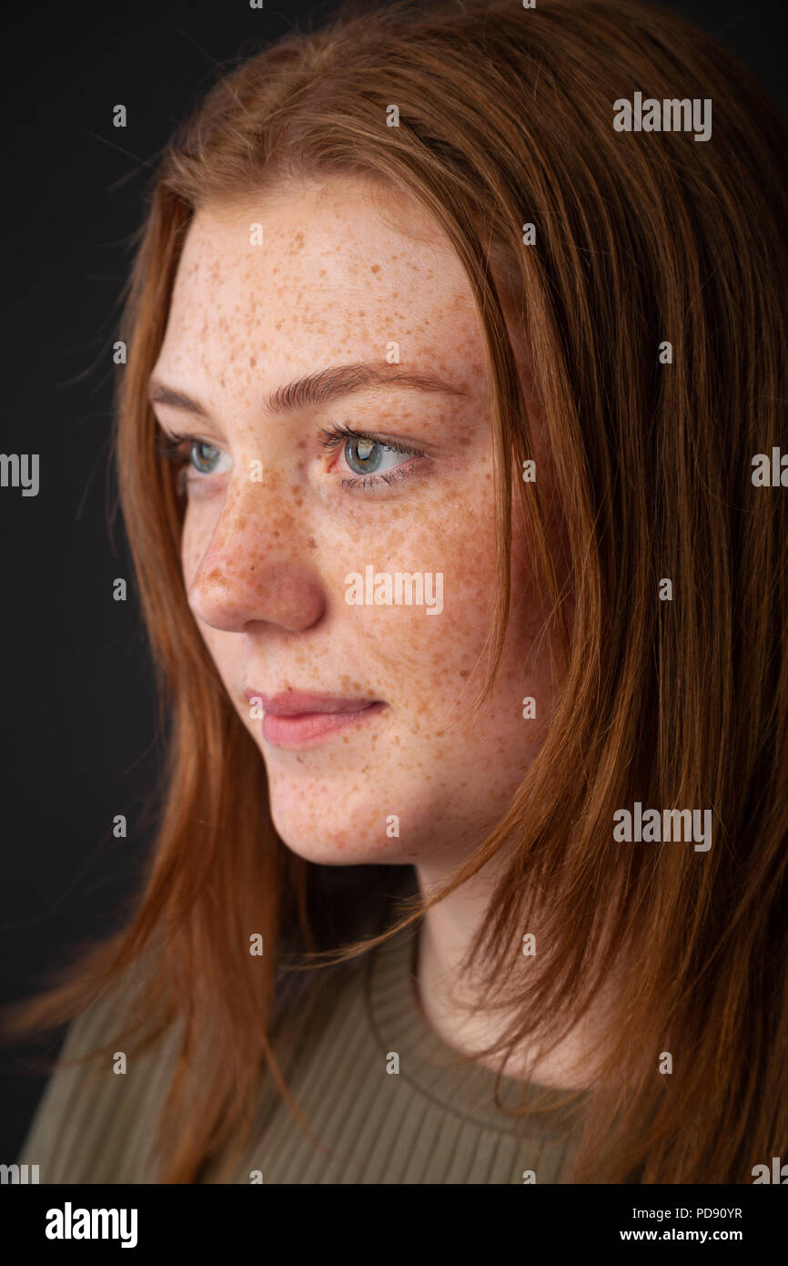 Un colpo di testa di profilo di una giovane donna con i capelli rossi e le lentiggini Foto Stock