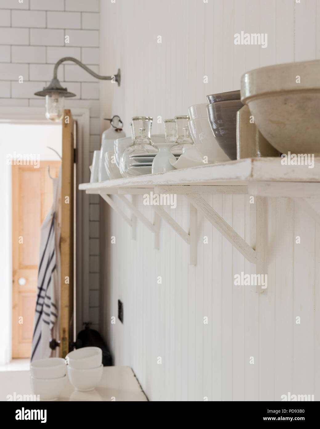 La ceramica su scaffali aperti in una cucina rustica Foto Stock
