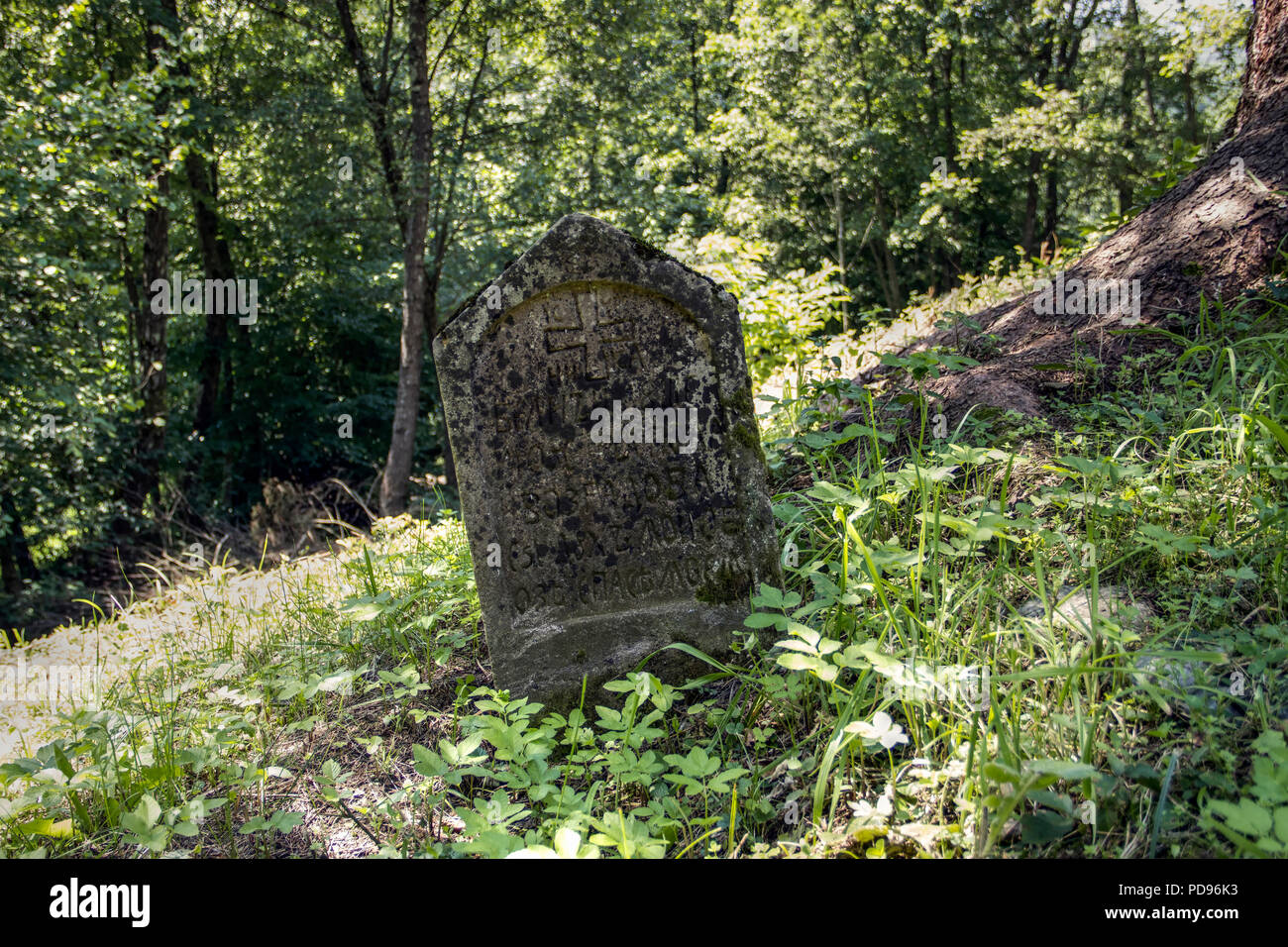 Villaggio Dub, Western Serbia - una lapide solitario in un cortile storico di log cabin Chiesa Ortodossa dell'assunzione di Cristo costruito nel 1792 Foto Stock