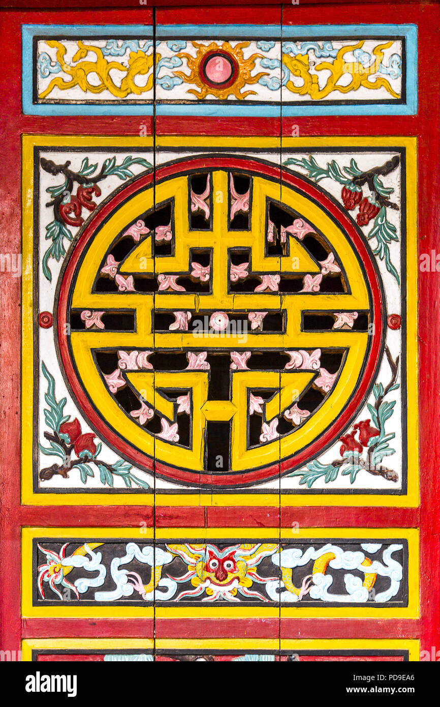 Area pubblica con un legno dipinto porta con design popolare nel senso di felicità, con predominanza di colori di giallo e rosso. Foto Stock