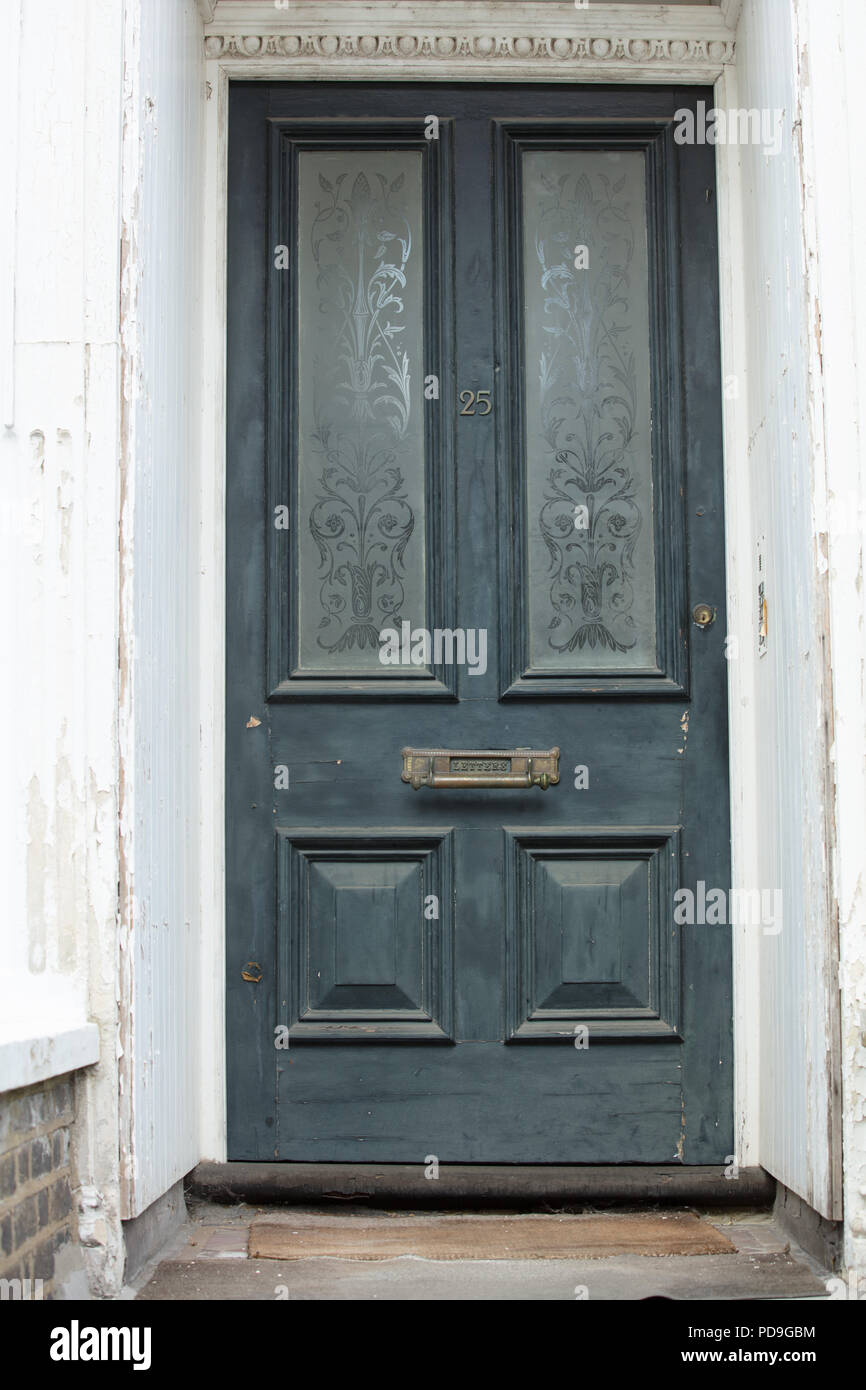 Portico e trascurata porta d'ingresso storico con pannelli di vetro visto a Londra UK. Foto Stock