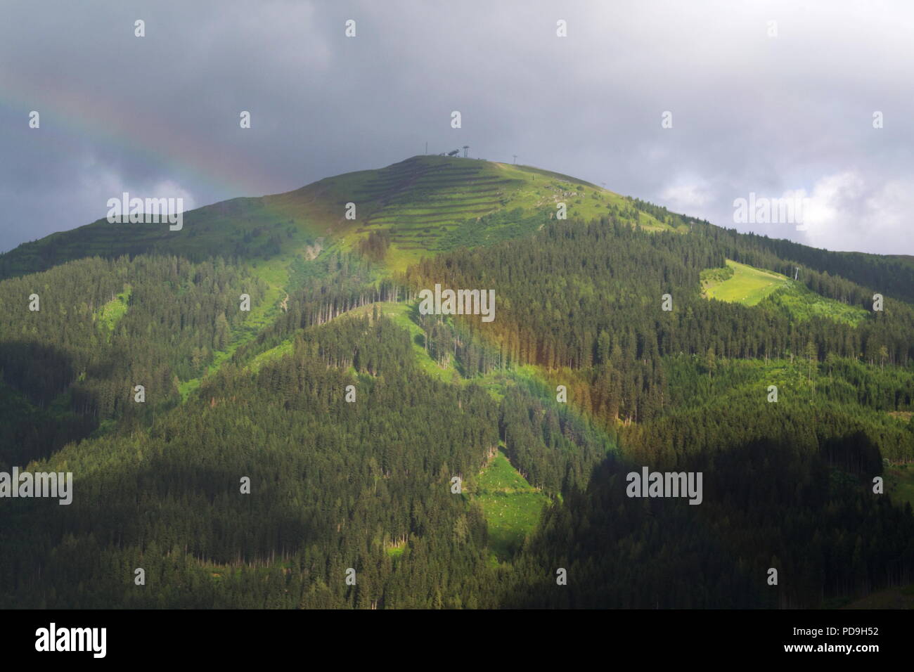 Rainbow su valle con Schattberg montagna, Saalbach-Hinterglemm, Austria Foto Stock