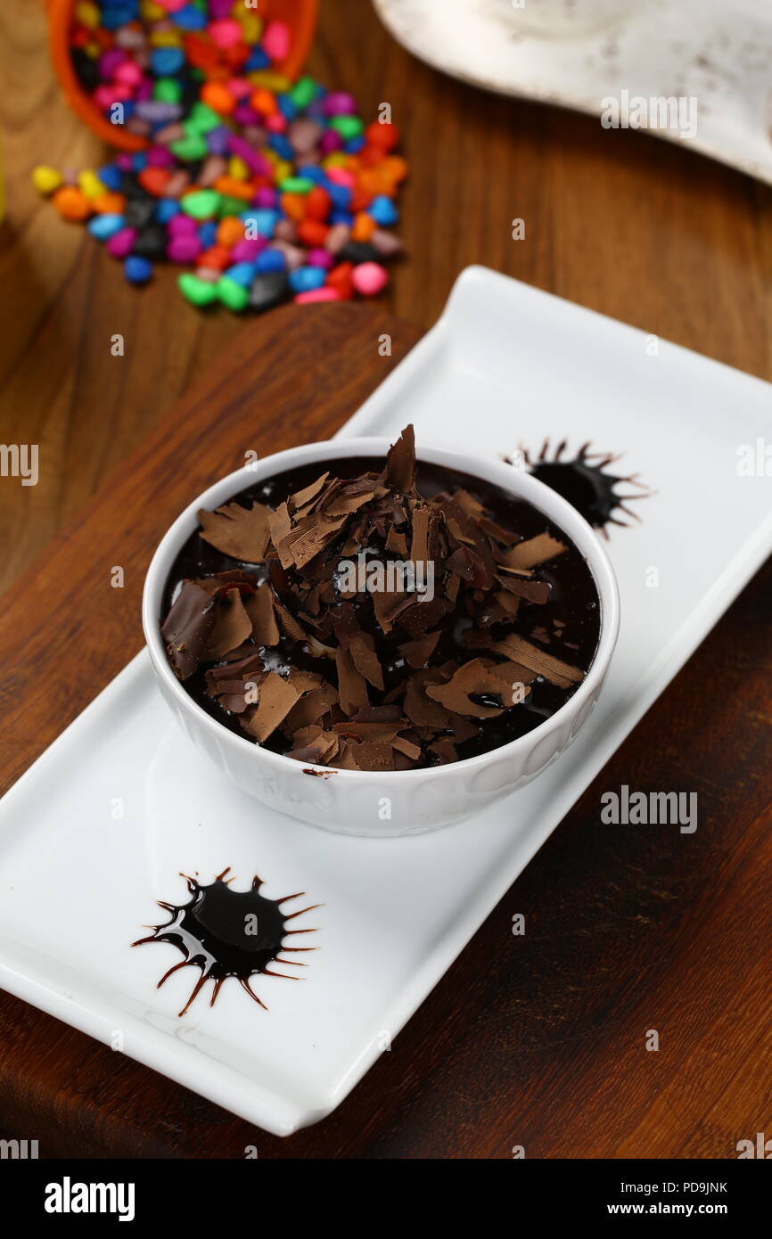 Gustosi profiteroles con crema e glassa di cioccolato su una piastra Foto Stock