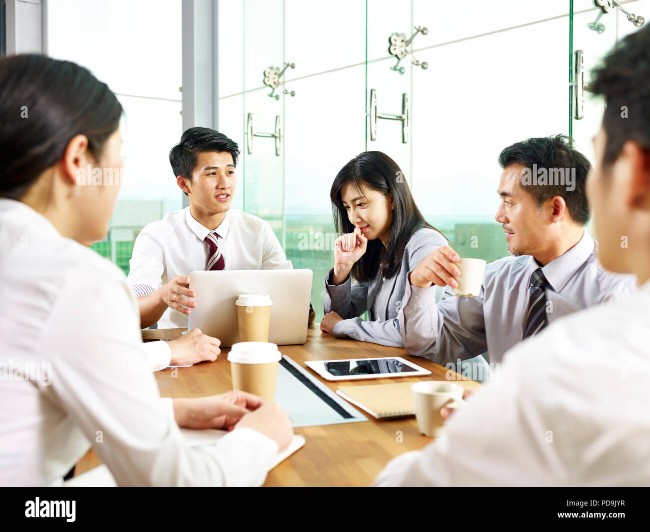 Team di asian business uomini e donne riuniti in un ufficio moderno. Foto Stock