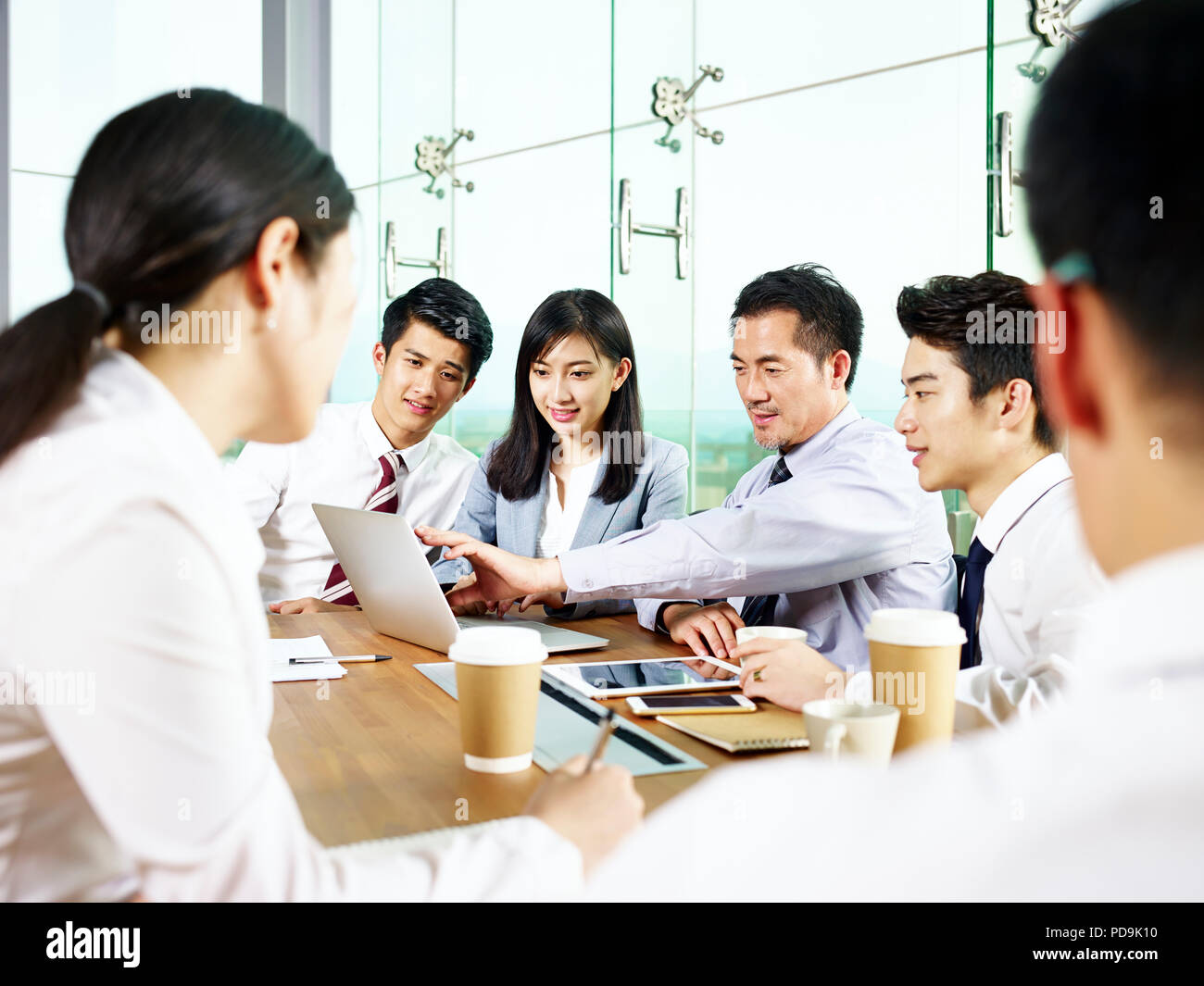 Team di imprenditori asiatici e imprenditrici riunione in ufficio moderno. Foto Stock