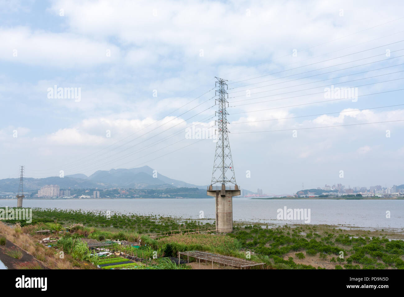 Linee elettriche ad alta tensione, torre di trasmissione di energia elettrica, pilone elevato su calcestruzzo con base a colonna, Tamsui River riverside, Luzhou, Taipei, Taiwan Foto Stock