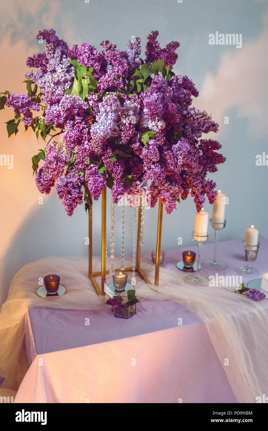 Composizione di fiori lilla sul tavolo in studio Foto Stock