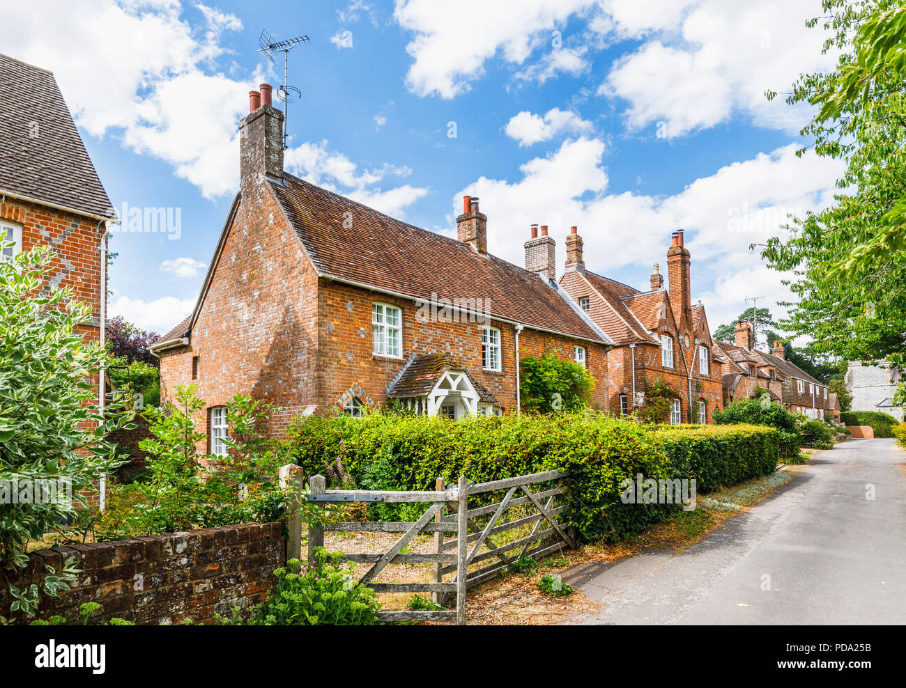 Mattoni rossi tipici cottages in un tranquillo vicolo del paese in poco Bedwyn, un piccolo villaggio rurale comunità nel Wiltshire, Inghilterra del sud in estate Foto Stock