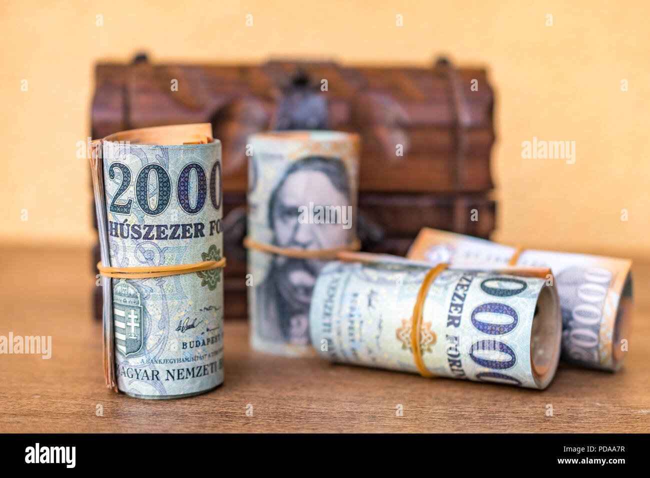 Arrotolato 20000 banconote in fiorini ungheresi con un annata di chiusura scatola di legno in background Foto Stock
