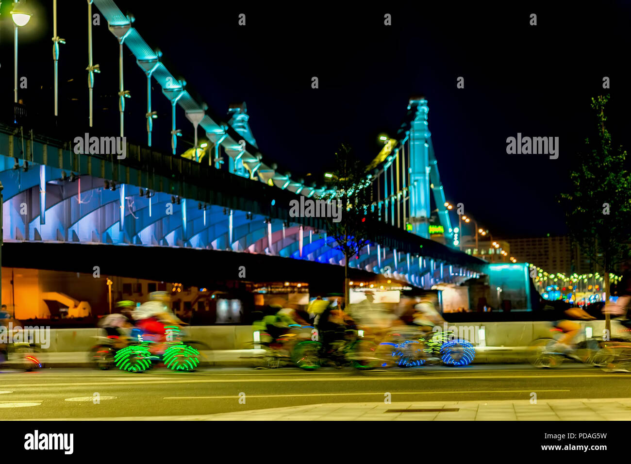 Abstract sagome di gruppo veloce colorato su un ponte di sfondo, città illuminazione notturna, motion blur. Concetto moderno di stile di vita sano Foto Stock