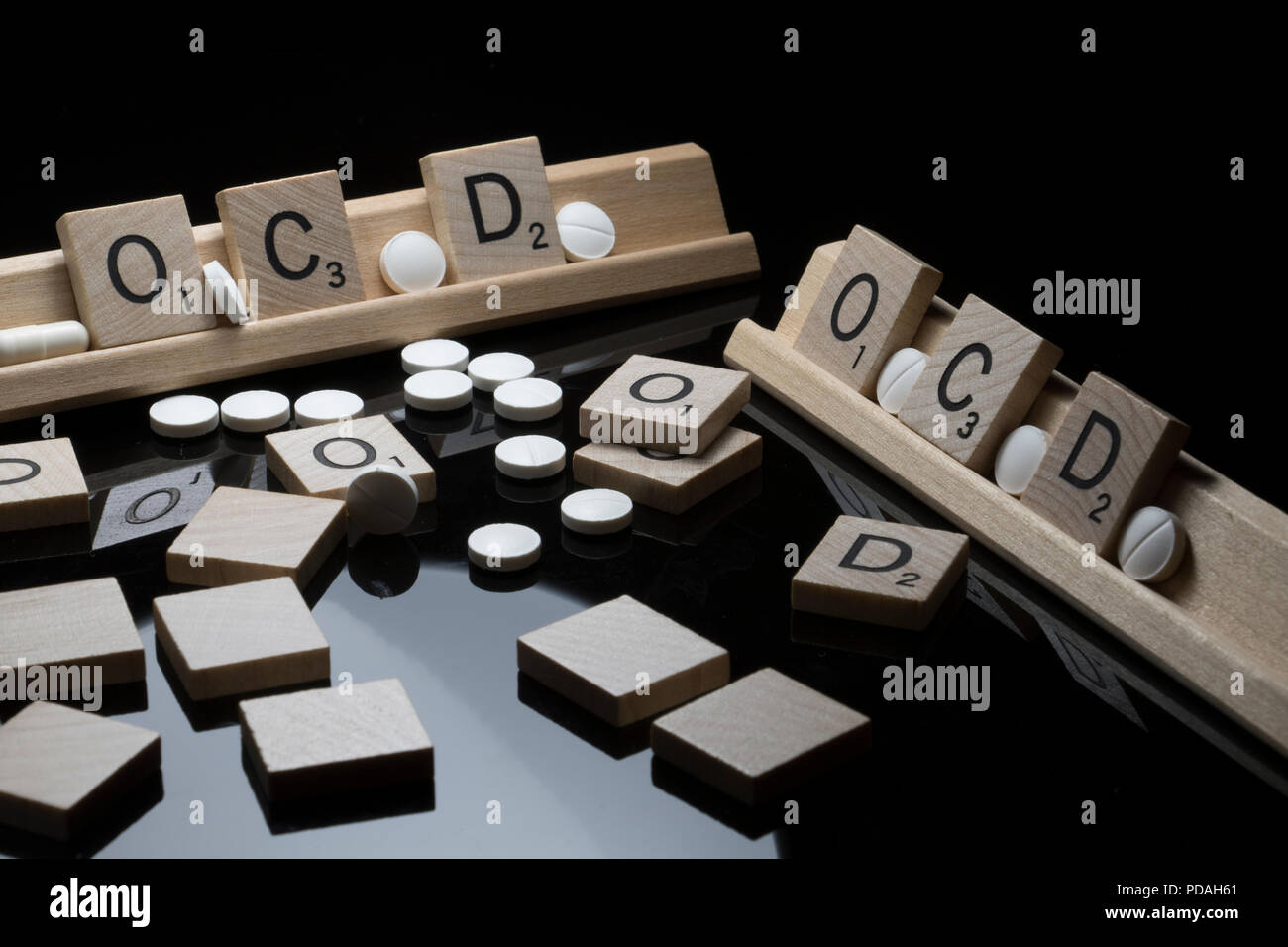 Lettere di Scrabble ortografia OCD con bianco pillole di prescrizione. Salute mentale concetto di sensibilizzazione. Foto Stock