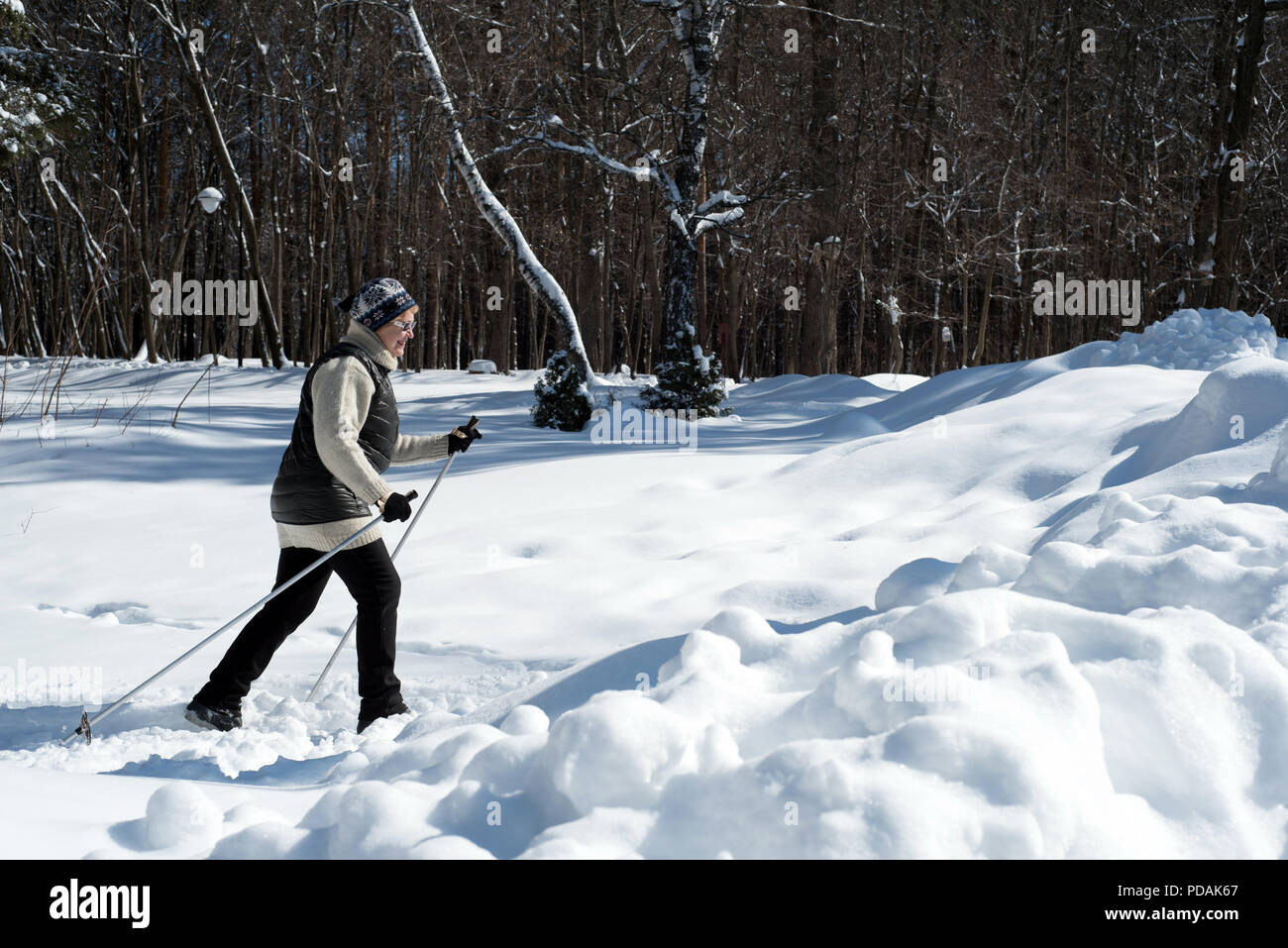 UFA, Russia 29marzo 2018 - Anziani donna che indossa gli sport invernali abbigliamento sci di fondo attraverso una pista forestale in nevicata utilizzando l'inverno sp Foto Stock