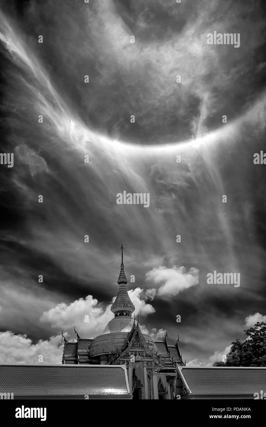 Sun fenomeni di anello 22° grado visto oltre un Thai tempio buddista. Thailandia del sud-est asiatico. La fotografia in bianco e nero cielo drammatico immagine monotono Foto Stock