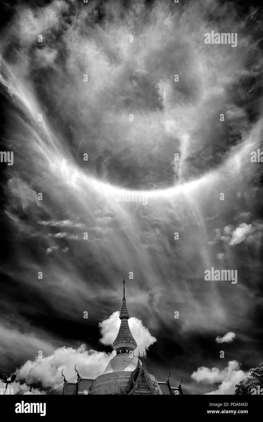 Sun fenomeni di anello 22° grado visto oltre un Thai tempio buddista. Thailandia del sud-est asiatico. La fotografia in bianco e nero cielo drammatico immagine monotono Foto Stock