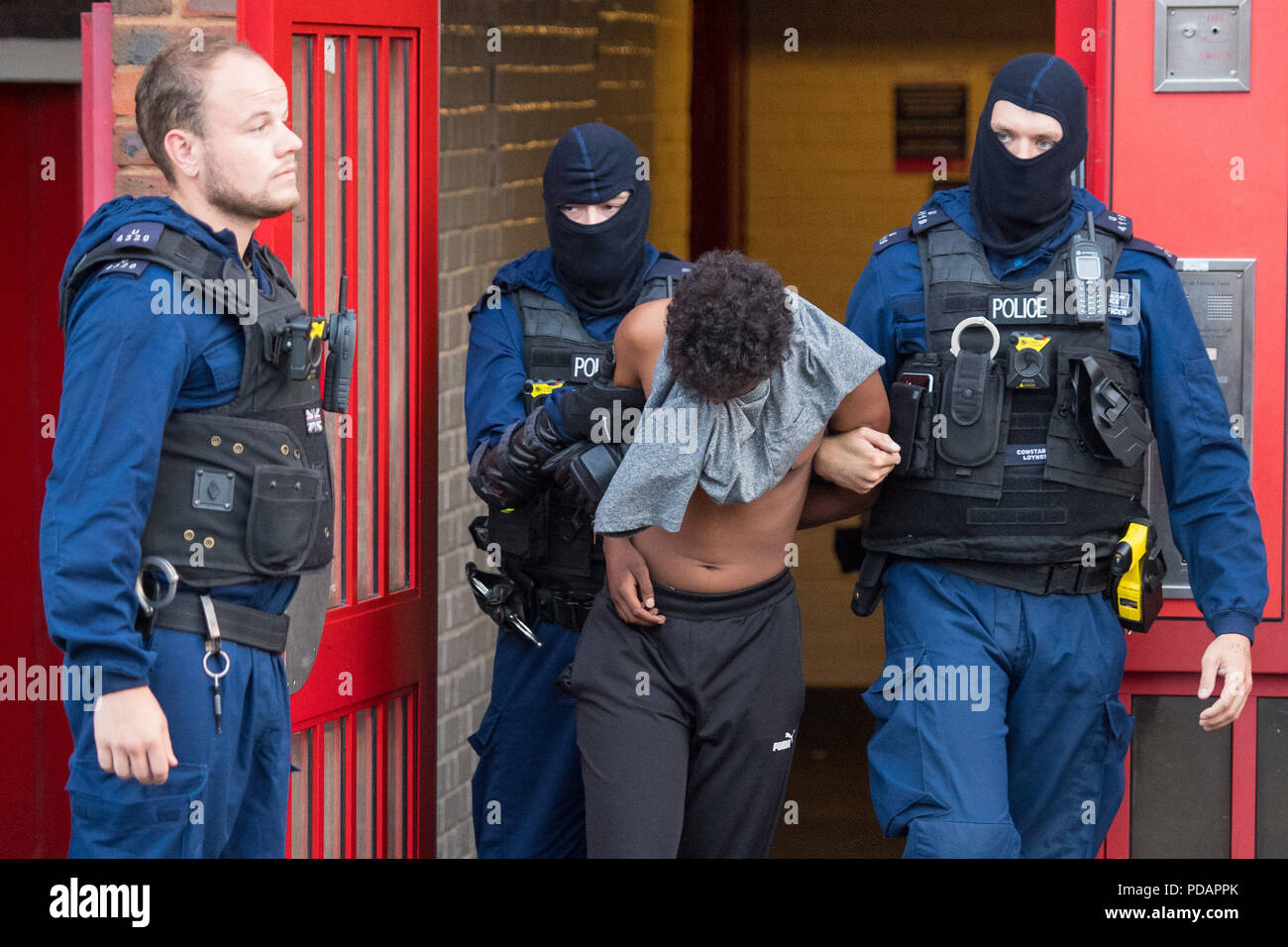 Gli ufficiali di polizia arrestato un uomo in corrispondenza di un indirizzo in Peckham, Londra Sud, durante una serie di incursioni di fronte ad una criminalità organizzata rete di distribuzione di farmaci nel sud di Londra. Foto Stock