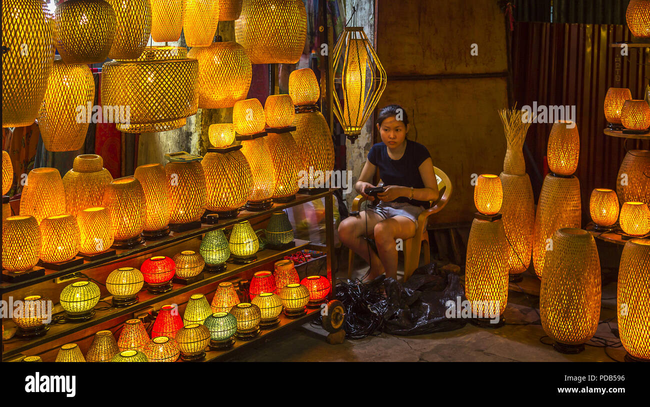 Editoriale: 14 agosto 2017 Antica Città di Hoi An, VN., Retail store con la ragazza asiatica addetto occupa il negozio nel mezzo di tutte le lanterne per la vendita. La Foto Stock