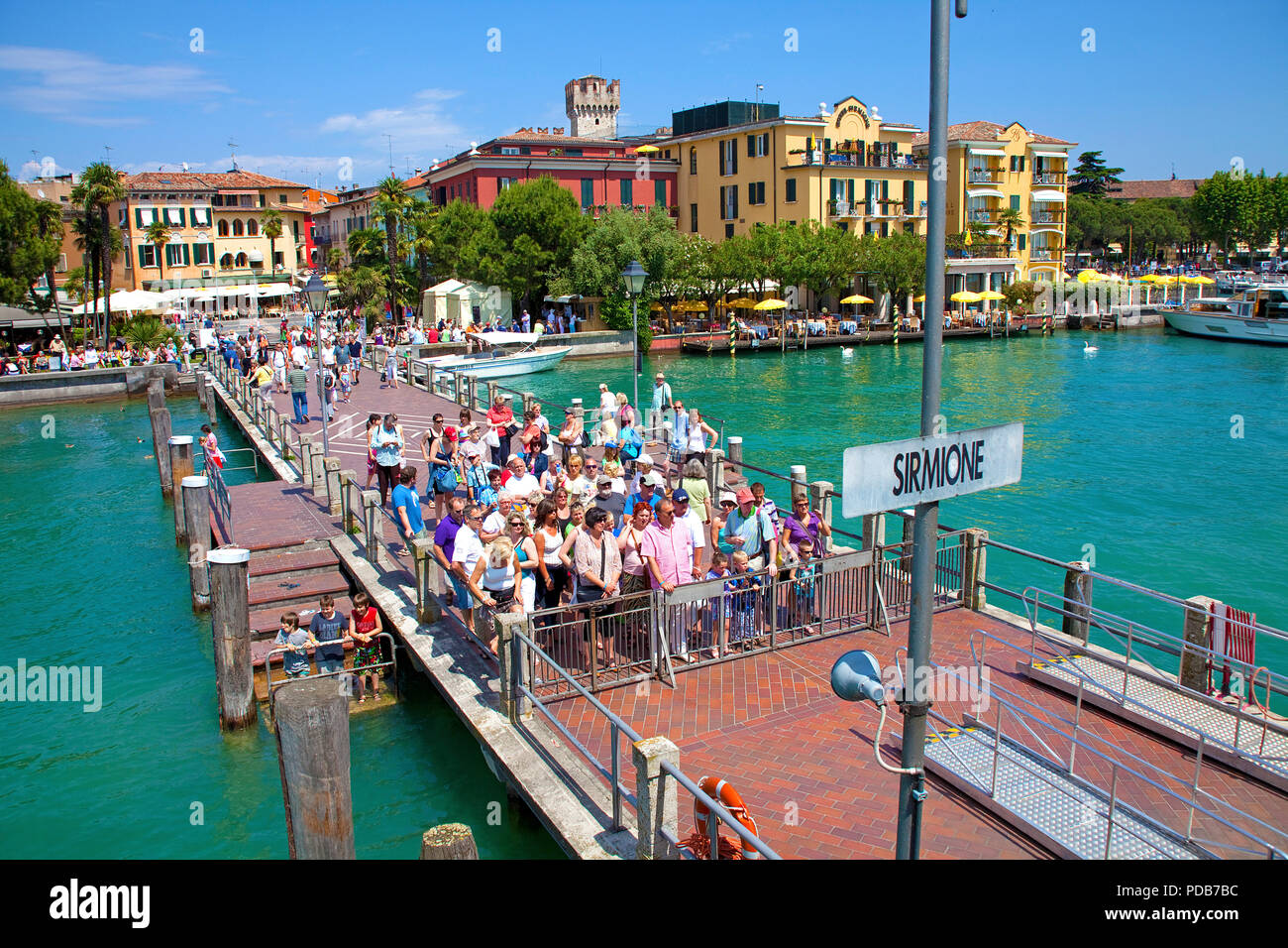 I turisti in attesa sul molo per l'escursione in barca, Sirmione sul Lago di Garda, Lombardia, Italia Foto Stock