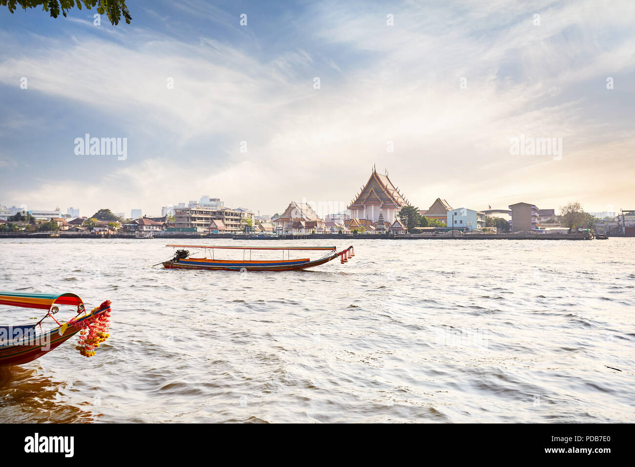 Tailandese tradizionale barca dalla coda lunga nel fiume Chao Phraya vicino al Wat Arun al tramonto a Bangkok, in Thailandia Foto Stock