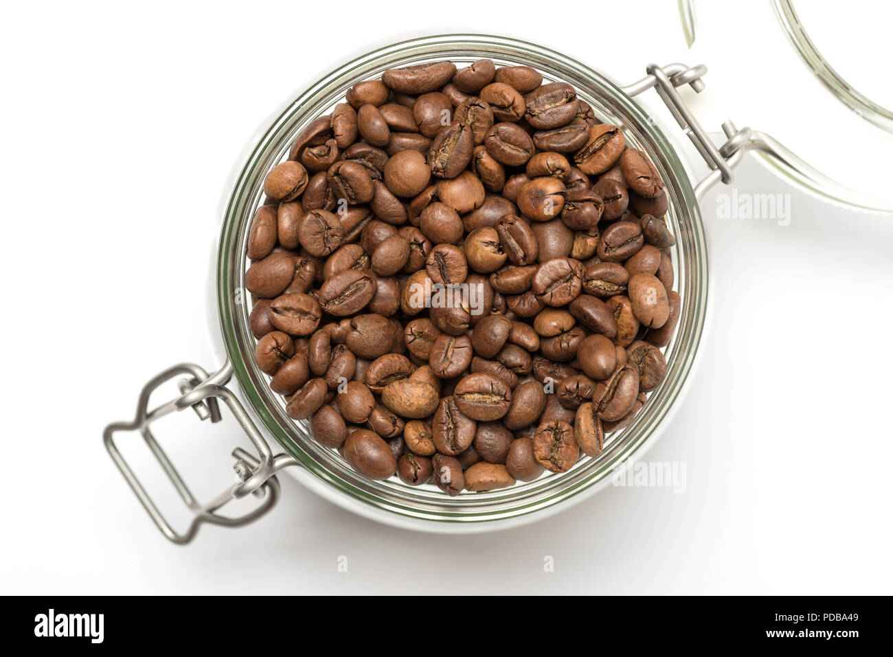 Chicchi di caffè tostati in clip top storage jar visto dal di sopra su sfondo bianco Foto Stock