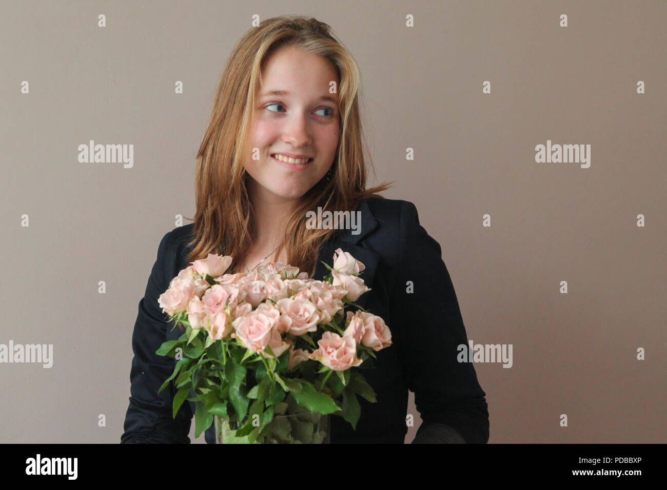 Felice giovane donna con bouquet di rose rosa Foto Stock