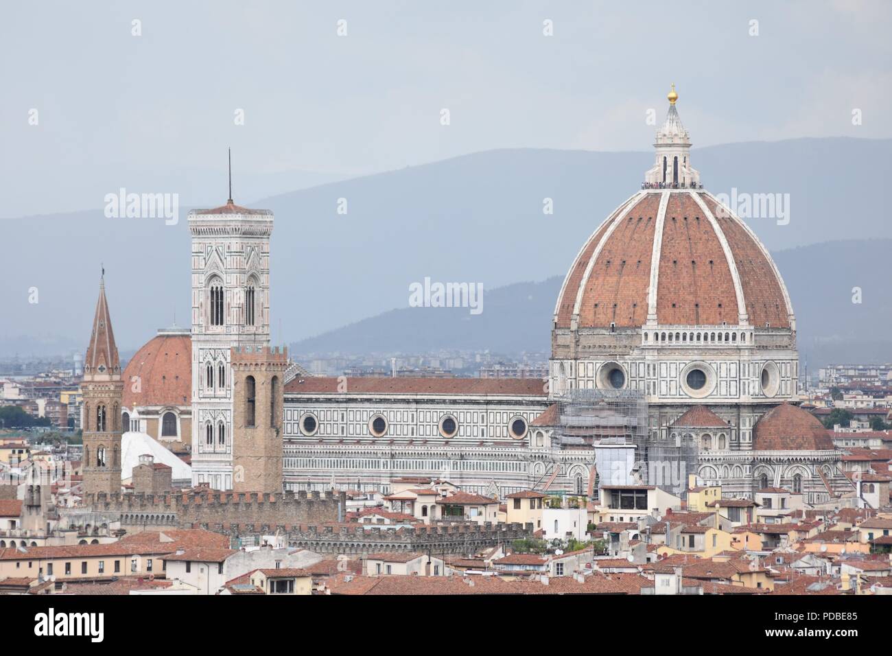 Antenna del teleobiettivo colpo di Firenze Duomo sopra i tetti di Firenze con lo sfondo delle montagne nebuloso e grigio cielo molto nuvoloso Foto Stock