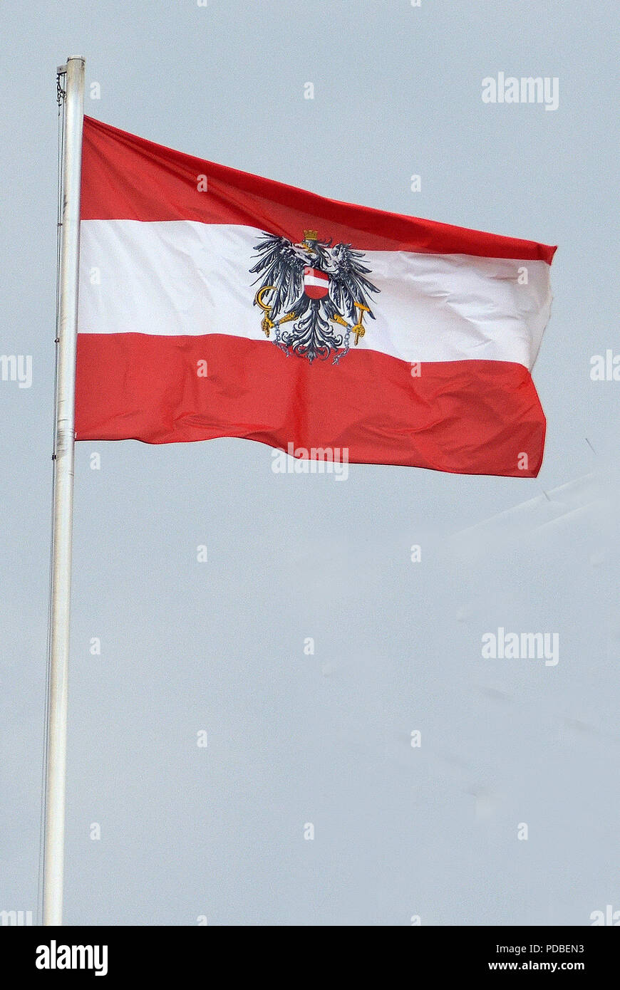 Bandiera nazionale della Repubblica di Austria con stato stemma presso la cancelleria federale sulla Ballhausplatz di Vienna - Austria. Foto Stock