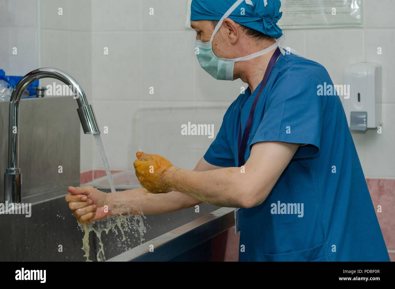 Il chirurgo è washching le sue mani egistrazione alle regole di sterilizzazione prima dell'operazione. Foto Stock