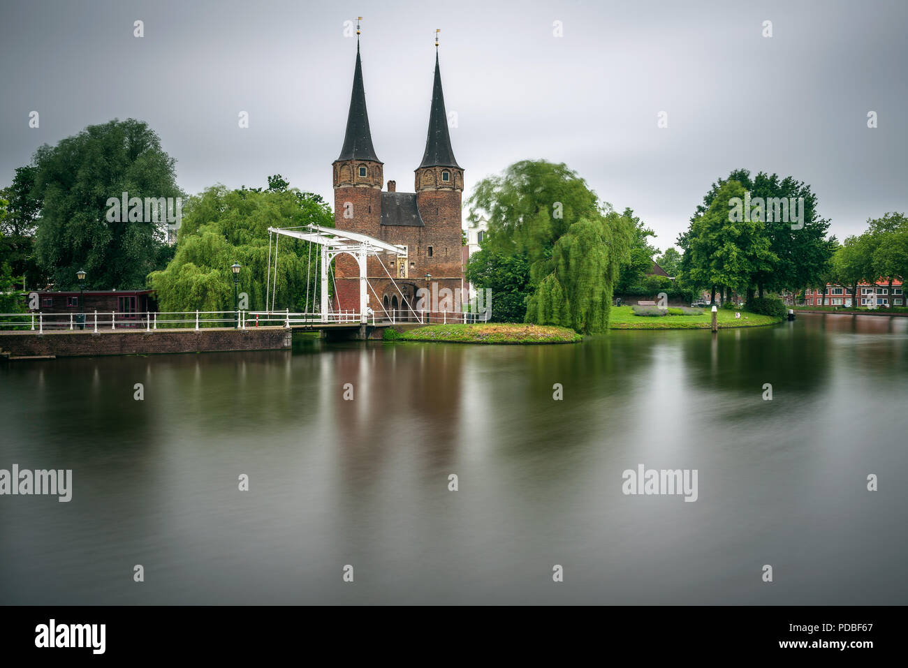 Porta orientale noto anche come Oostport, canale antico e storico ponte levatoio in Delft, Paesi Bassi. Lunga esposizione. Foto Stock