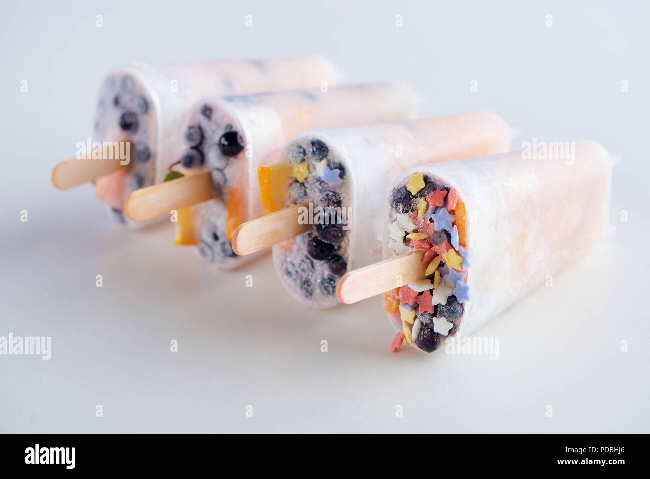 Vista ravvicinata di freschi congelati popsicles fatti in casa con frutti e bacche su grigio Foto Stock