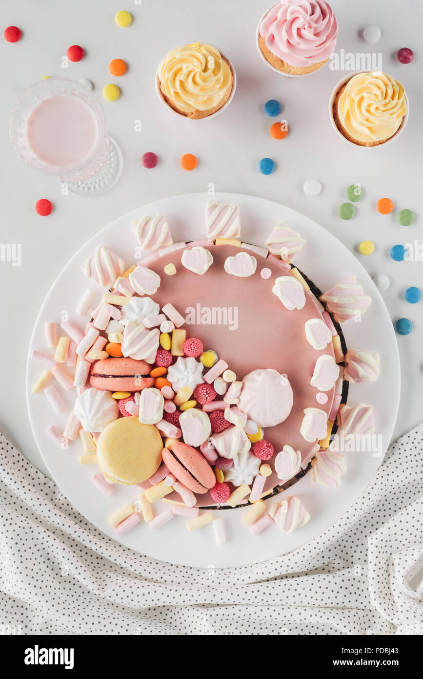 Vista superiore della torta di compleanno con marshmallows, caramelle e  dolci tortine su tavola Foto stock - Alamy