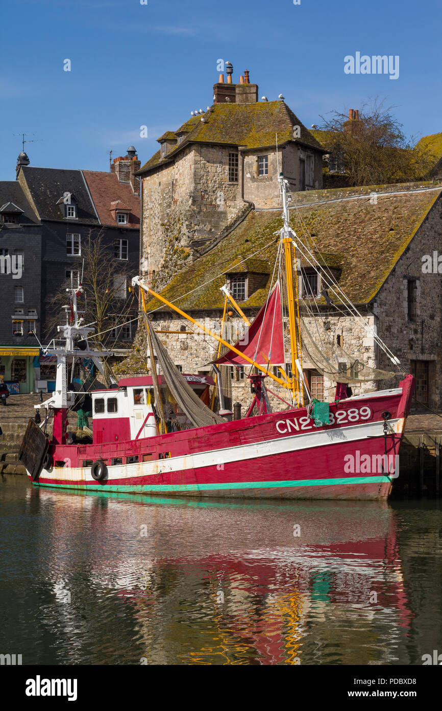 Un colorato vintage in legno rosso barca da pesca di fronte a La Lieutenance nel vecchio porto, le Vieux Bassin, a Honfleur, Normandia, Francia Foto Stock