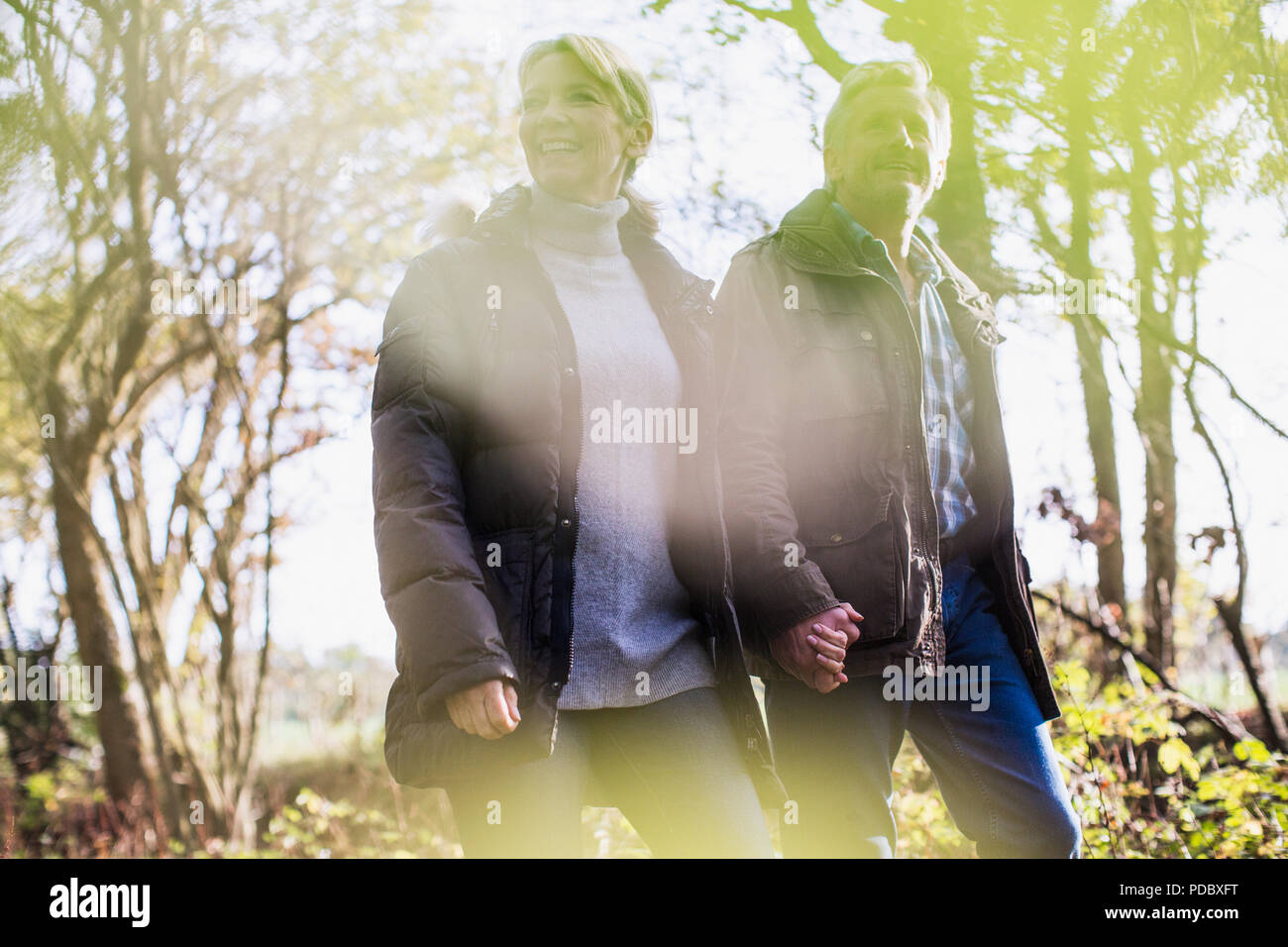 Coppia matura Holding Hands, passeggiate nel parco di autunno Foto Stock