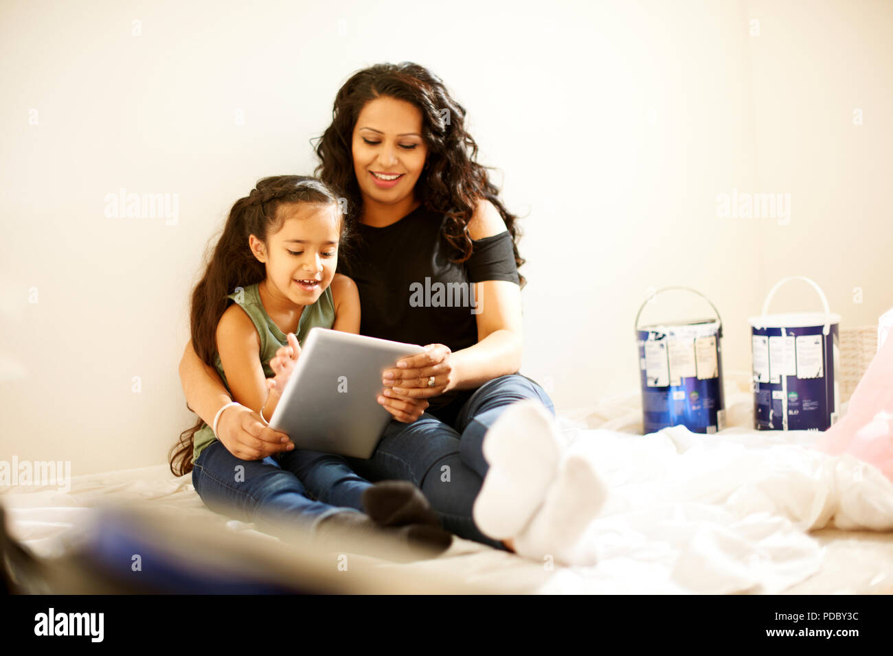 Madre e figlia con tavoletta digitale prepara il progetto di pittura Foto Stock