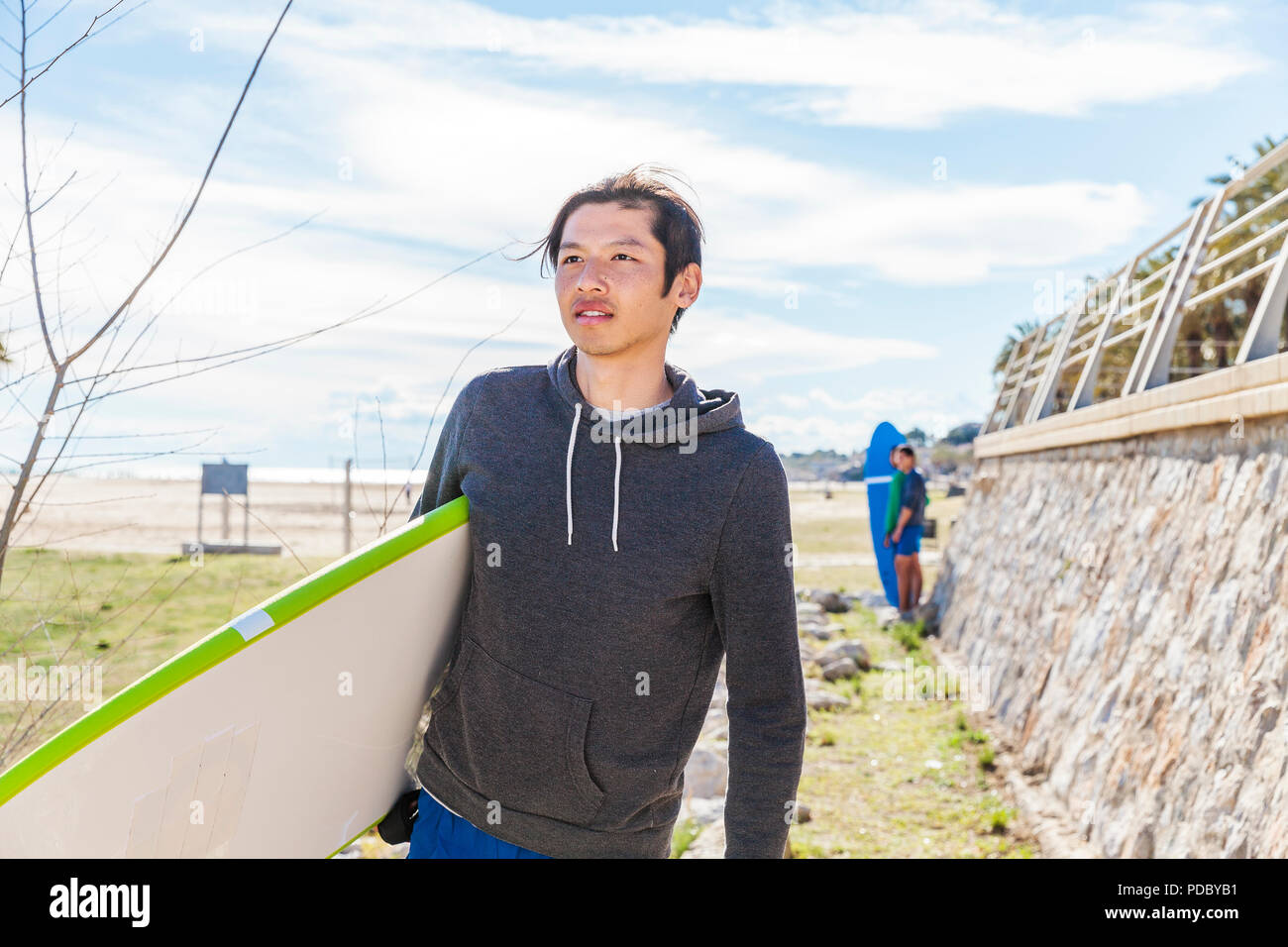 Surfista maschio che trasportano le tavole da surf di sunny beach Foto Stock